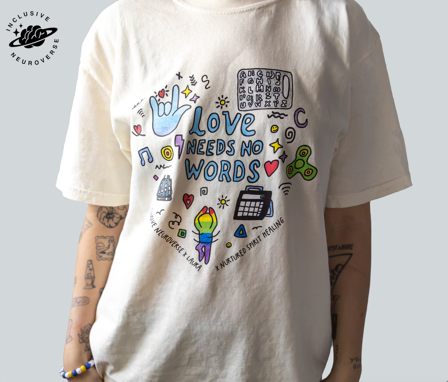 Adult wearing matching “Love Needs No Words” collab t-shirts by Laura, promoting autism acceptance and neurodiversity.
